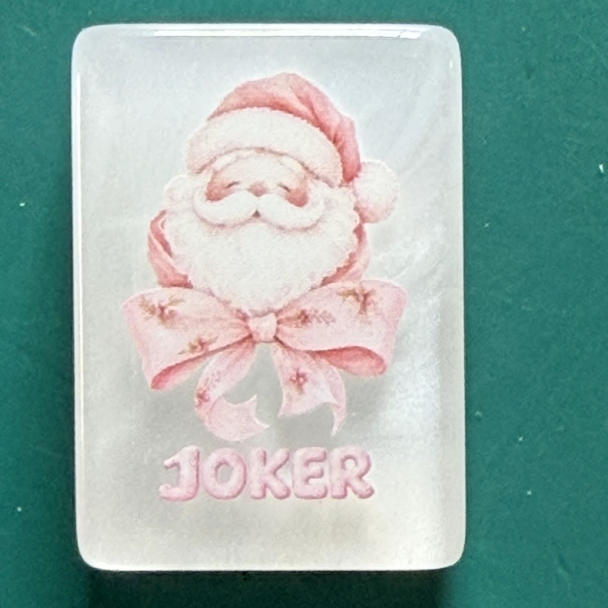 Macro close-up of the Pink Santa Joker tile showing 11mm pearlescent acrylic and UV print